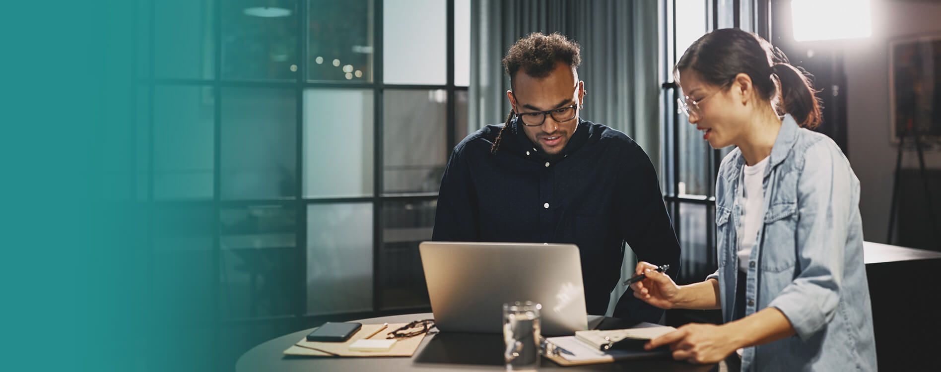 Two business teammates collaborating at a laptop